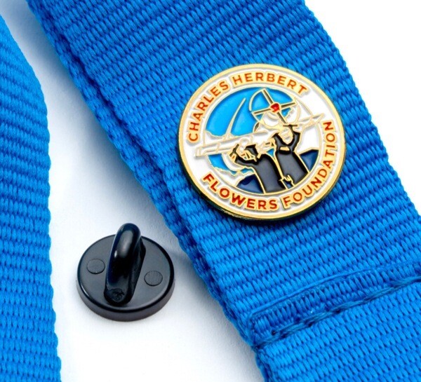 Charles Herbert Flowers Foundation enamel pin on a blue lanyard