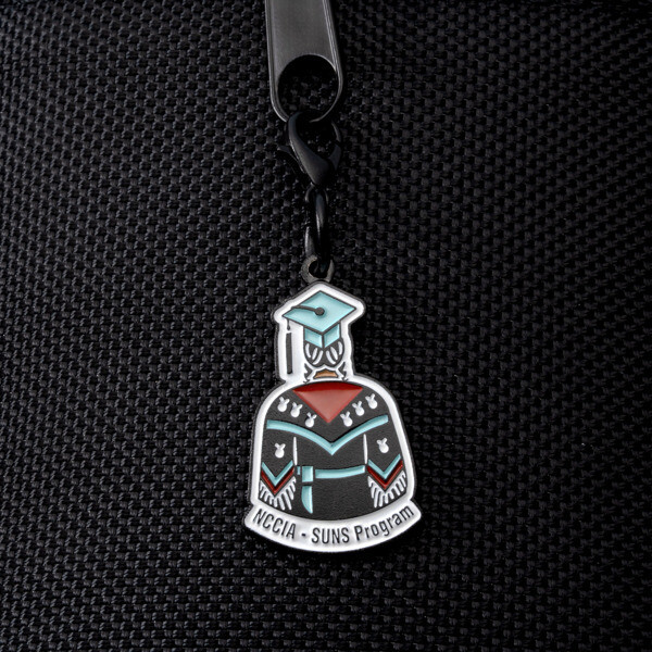 NCCIA SUNS Program graduate zipper pull clipped to a black bag zipper